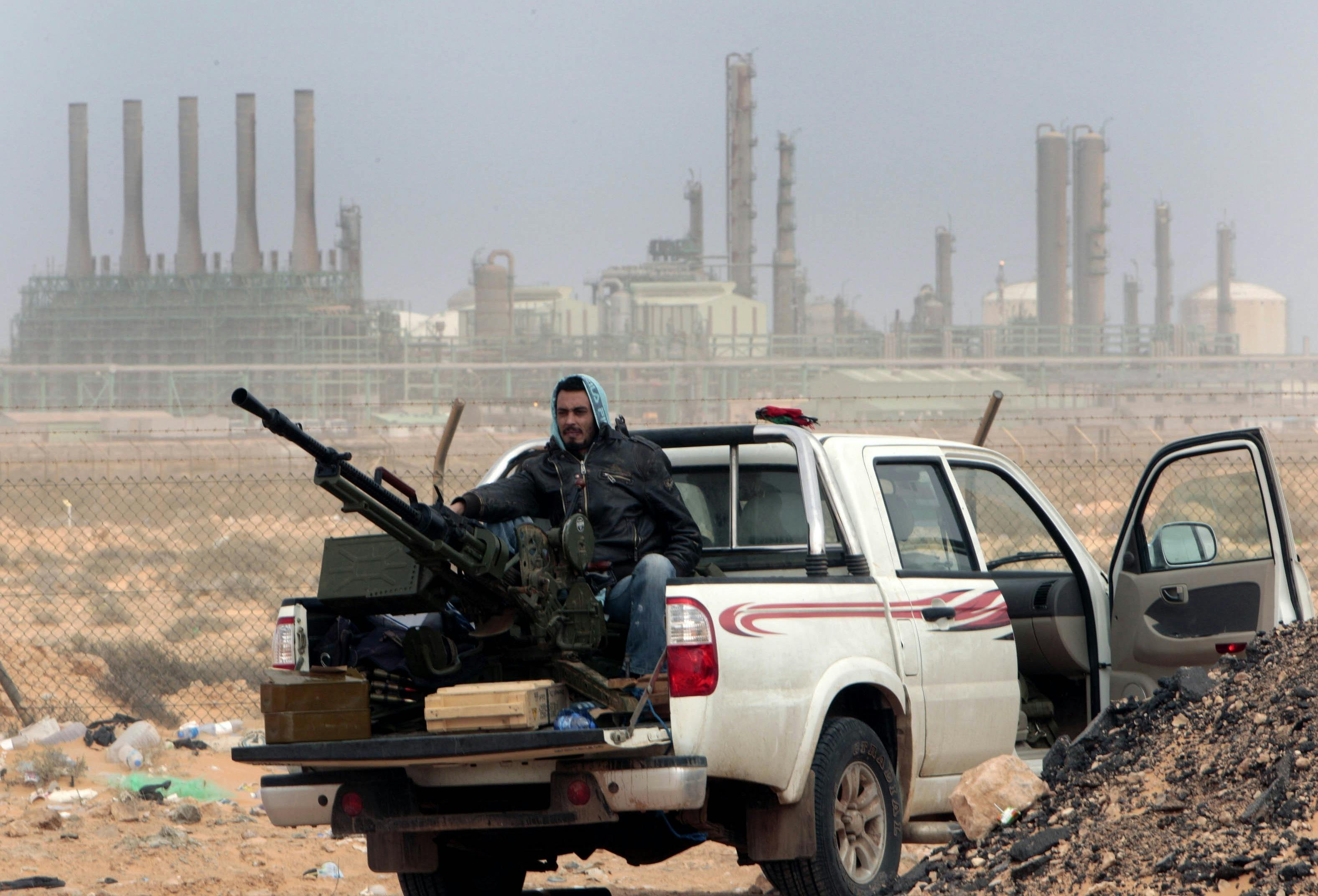 Anti-government Libyan rebel in front of oil refinery 